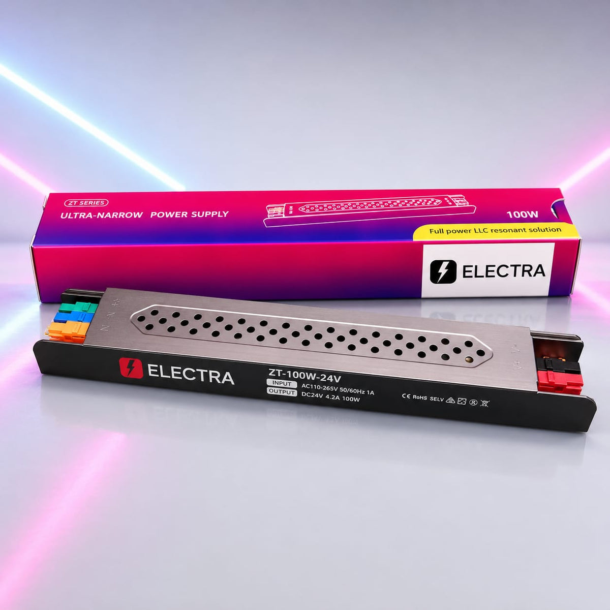 Electra ZT-100W-24V ultra-narrow power supply unit shown in front of its retail box on a reflective studio surface with pink neon light streaks in the background.